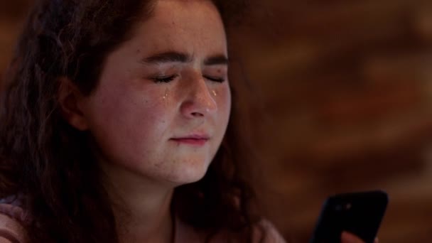 Mladá žena mají depresivní náladu ve své ložnici ona dívá na svůj smartphone a pláče tvrdě — Stock video