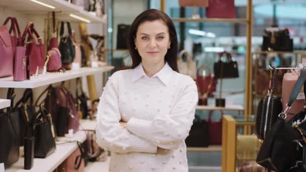 Increíble mujer supervisora con una gran sonrisa mirando directamente a la cámara y cruzando las manos en la tienda de accesorios — Vídeos de Stock