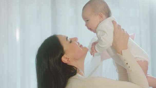 Feliz y sonriente gran hermosa madre joven disfrutar del tiempo con su bebé niña que sostiene a su hija y se siente emocionada — Vídeos de Stock