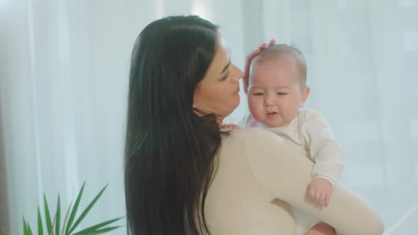 Menina bonito e bonito na manhã acelerando o tempo com sua mãe, enquanto a jovem mamãe segurando o bebê em seus braços. Tiro em ARRI Alexa Mini. — Vídeo de Stock