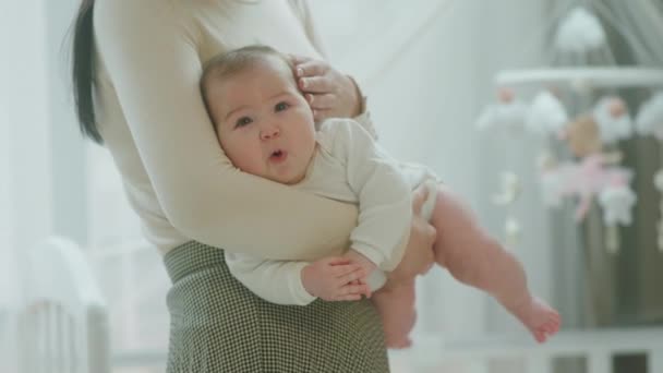 Detalhes close up cute baby girl aproveite o momento nas mãos de sua mãe na manhã bebê sentindo-se relaxado e feliz — Vídeo de Stock