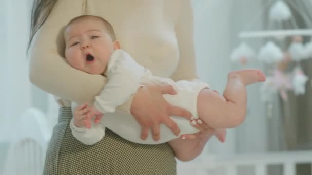 После утренней рутины мама берет ребенка на руки и наслаждается моментом, когда симпатичный малыш расслабляется и чувствует себя счастливым — стоковое видео