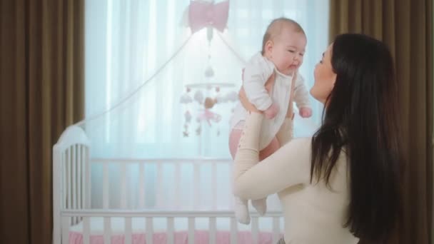 Im Schlafzimmer süße kleine Mädchen Beschleunigung der Zeit mit ihrer jungen Mutter Dame umarmt vorsichtig das Baby und zusammen spielen — Stockvideo