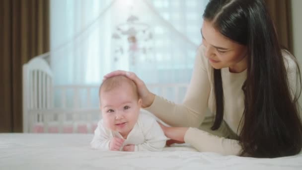 Por la mañana sonriente madre feliz jugando con su bebé en la cama juntos concepto de maternidad lactante infancia y bebé — Vídeos de Stock