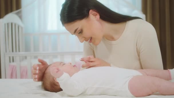 Sehr nettes Baby Mädchen und ihre Mutter haben eine schöne Zeit Mutter umarmt mit Liebe das Baby und rühren Gesicht zu Gesicht Konzept der Familie Kindheit und Mutterschaft — Stockvideo