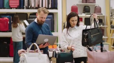 Küçük işletme ve girişimci kavramı kameranın önünde, aksesuar mağazasında satış elemanı ve denetçi birlikte çalışırken dizüstü bilgisayarında ürünün yeni fiyatını fark ediyor.