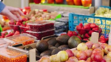 Organik sebze dükkanındaki taze hasat ve tarım endüstrisi müşterisi kavramı taze avokado alıyor. ARRI Alexa Mini 'de çekilen.