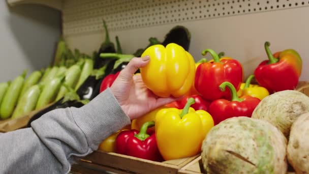 Gazdálkodási ipar és az egészséges életmód koncepció a zöldségbolti vásárló vesz egy érett sárga édes papírt a fa polcokról — Stock videók