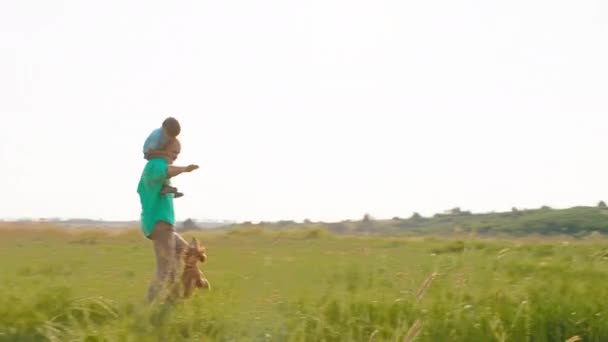 Cute small boy on the his dad back running and playing together with their cute small dog English cocker spaniel — Stock Video