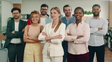 Bir grup işçi, kollarını kavuşturup önde güzel bir kadınla bir sırada dururken doğrudan kameraya bakıyorlar. Arri Alexa Mini.