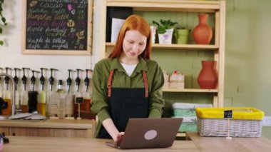 Kahve dükkanında çalışan siyahi bir barista, arka planda iş arkadaşıyla birlikte çalışan bir müşteriye bir kafe yapar.