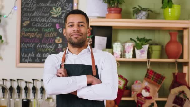 Concept van kleine bedrijven en ondernemer zwarte man zeer charismatisch met een grote glimlach op tue coffeeshop bureau staan en poseren voor de camera kruising handen — Stockvideo