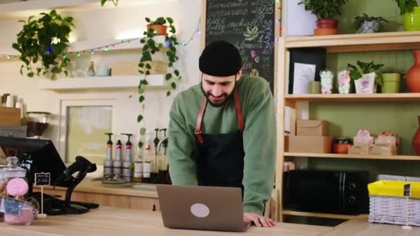 Concept van kleine onderneming en ondernemer in de gezellige coffeeshop barista guy neemt de bestelling van de klant dame — Stockvideo