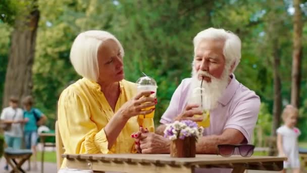 Χαρισματικό ηλικιωμένο ζευγάρι πολύ ρομαντικό χρόνο υπερβολική ταχύτητα μαζί στο καφέ αγκαλιάζοντας ο ένας τον άλλο και πίνοντας κάποια λεμονάδα — Αρχείο Βίντεο