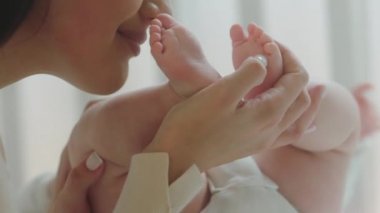 Sabahları güzel bir annenin bebek bacaklarıyla oynayıp onları tutkuyla öperkenki videosu çok şirin.