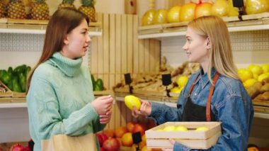 Sebze dükkanında organik tarım yiyeceği kavramı karizmatik müşteri birlikte tartıştıkları çiftçiden taze limon almak istiyor.