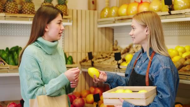 Sebze dükkanında organik tarım yiyeceği kavramı karizmatik müşteri birlikte tartıştıkları çiftçiden taze limon almak istiyor. — Stok video