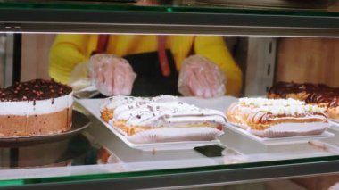 Kafe satıcısının kamerasına yakın çekim. Vitrin dolabına taze tatlı çöl koydum. - Evet. ARRI Alexa Mini 'de çekilen.