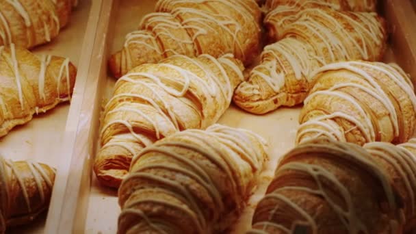 Delante de la cámara en el café de la panadería tomando el primer plano video de croissants franceses frescos de la nevera escaparate. 4k — Vídeo de stock