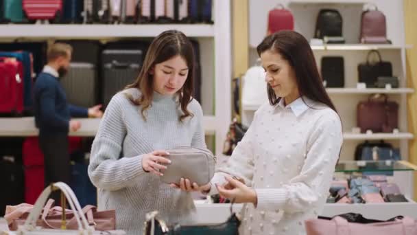 Концепция развлечения и малого бизнеса симпатичная женщина-клиент и зрелая продавщица беседуют о вещах от продавщицы держа розовую сумку в руках. Снимок на ARRI Alexa Mini. — стоковое видео
