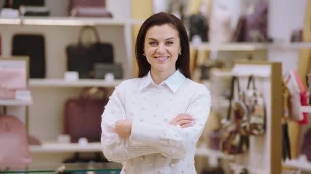 Concepto de empresaria guapa supervisora posando delante de la cámara y cruzando las manos y sonriendo a lo grande en la tienda de accesorios — Vídeos de Stock