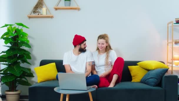 Helg tid för ett ungt par stanna hemma i vardagsrummet tillbringa tid tillsammans titta på några komedi på laptop — Stockvideo