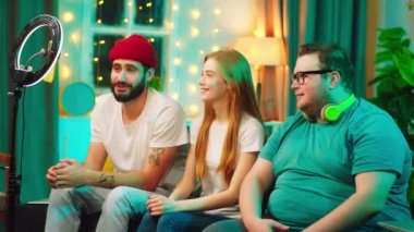 Sosyal medyadan etkilenen kadın ve iki kişi canlı yayında videoyu kaydetmek için akıllı telefon ve ışık kullanıyorlar.