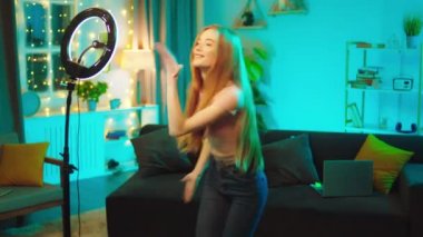 Sosyal medya hesabı için ışık halkası kullanarak akıllı telefonuyla video kaydeden güzel bir genç bayan etkin.