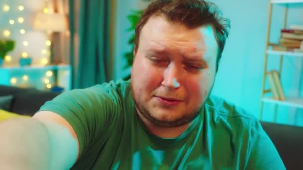 Плачущий толстяк перед камерой он записывает видео, говоря о чем-то очень грустном, что он расстроен. 4k — стоковое видео