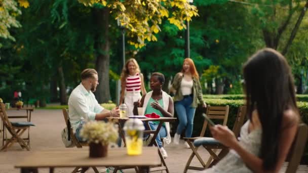 Carismático pareja multirracial negro mujer y rubia cabello chico tener un encuentro con otros amigos dos hermosas damas que se reúnen en el café — Vídeo de stock