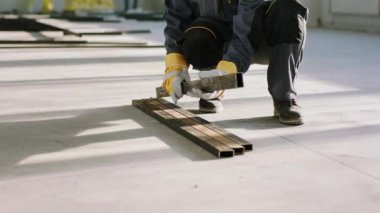 Closeup to the camera details of a construction worker at construction site working with heavy building materials