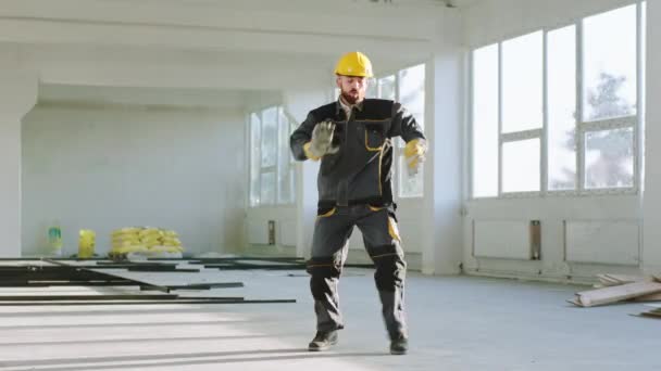 Happy and excited construction worker at construction site dancing and enjoy the moment he wearing uniform and safety helmet — Stock video