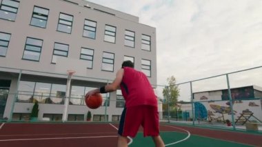 A tall man playing basketball in a modern stadium he throw the basketball in the basket
