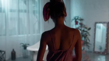 In a modern bathroom lady take off her pyjama and get ready for a bath to enjoy the evening