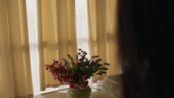 Una mujer abre alegremente las cortinas y sonríe ampliamente mientras ve la increíble vista de la ciudad. 4k — Vídeo de stock