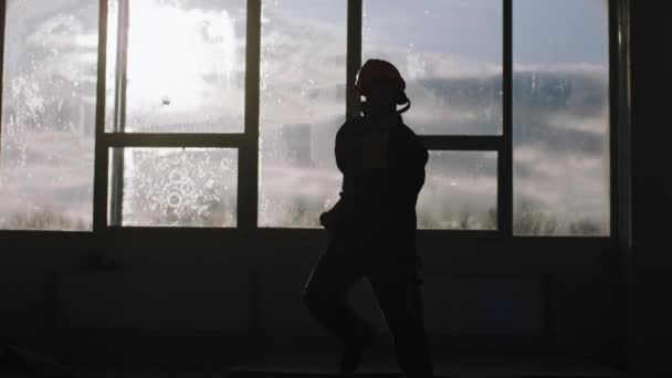 Au coucher du soleil chantier de construction travailleur de danse avec équipement de sécurité et casque avec vue panoramique devant la caméra — Video