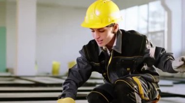 Closeup to the camera charismatic and dancing petty woman constructor worker she working at construction site and enjoy the time at work wearing safety helmet and uniform