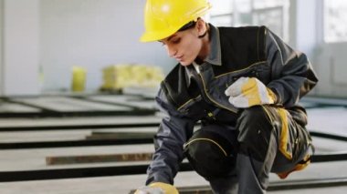 In front of the camera constructor worker young woman very charismatic with safety helmet and protective uniform painting some building materials