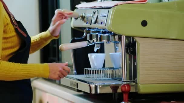 Avvicinamento alla macchina fotografica nel bar della caffetteria le mani della barista fanno un caffè alla macchina da caffè professionale — Video Stock