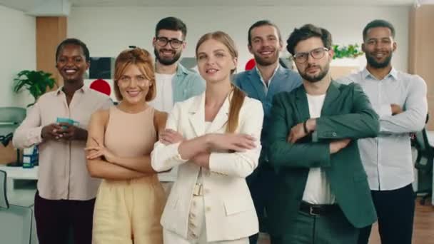 Унікальна і відмінна група з семи робітників стоять у формі в їх офісі, будучи щасливими під час перетину своїх рук — стокове відео