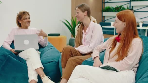 I en modern business center grupp av karismatiska kvinnor diskuterar på rasten något mycket intressant — Stockvideo