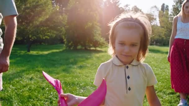 Delante de la cámara primer plano niño carismático sus padres caminando por el parque juntos disfrutar de la hora del fin de semana — Vídeos de Stock