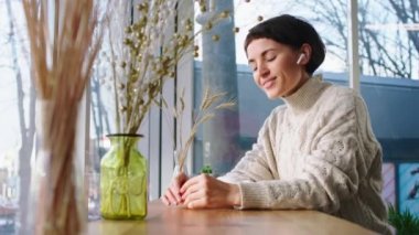 Kahve dükkanında karizmatik ve güzel bir bayan kahve fincanını eline alıp pencereden bakarken bir şey düşünüyor.