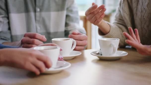 Prendre des détails à proximité de l'appareil photo dans le groupe de café des jeunes prennent leur café le matin quelqu'un mélanger le sucre de la tasse — Video