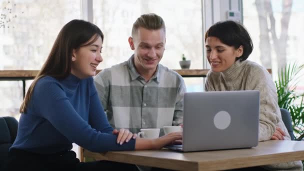 Bir grup karizmatik ve güler yüzlü iri arkadaş iki bayan bir adamla kahve dükkanında buluşup bir şeyler izlemek ve tartışmak için dizüstü bilgisayar kullanıyorlar. ARRI Alexa Mini 'de çekilen — Stok video