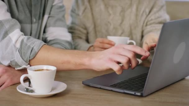 Närbild på kameran två personer gestikulerar med händerna på den bärbara datorn medan du dricker kaffe på kafé — Stockvideo