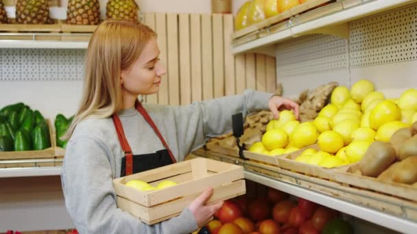 Organik sebze dükkanındaki karizmatik kadın çiftçi taze limonu ahşap raflara dikkatlice yerleştirin. — Stok video