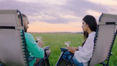 Genç çift birlikte güzel görünüyor. Doğanın ortasında komik zamanlar geçiriyorlar. Büyük bir gülümsemeyle tarlanın ortasında otururken bir şeyleri tartışıyorlar.