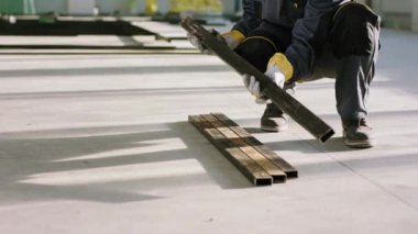 İnşaat alanındaki detaylar. Ağır inşaat malzemeleriyle çalışmak için koruyucu eldiven kullanan bir işçi çok çalışıyor.