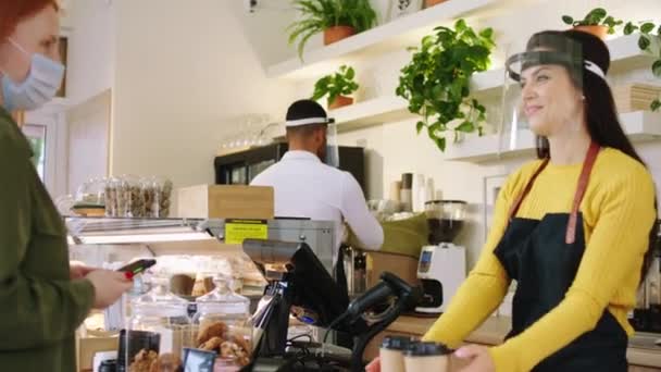 Concept de femme mature barista COVID 2019 avec un joli sourire donnant l'ordre au client et ramasser une autre commande d'un autre client dans le café bar — Video